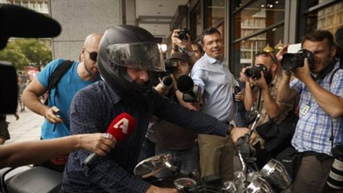 Yanis Varoufakis, rodeado de cámaras al abandonar ayer su oficina.-Foto: AP /DANIEL OCHOA DE OLZA