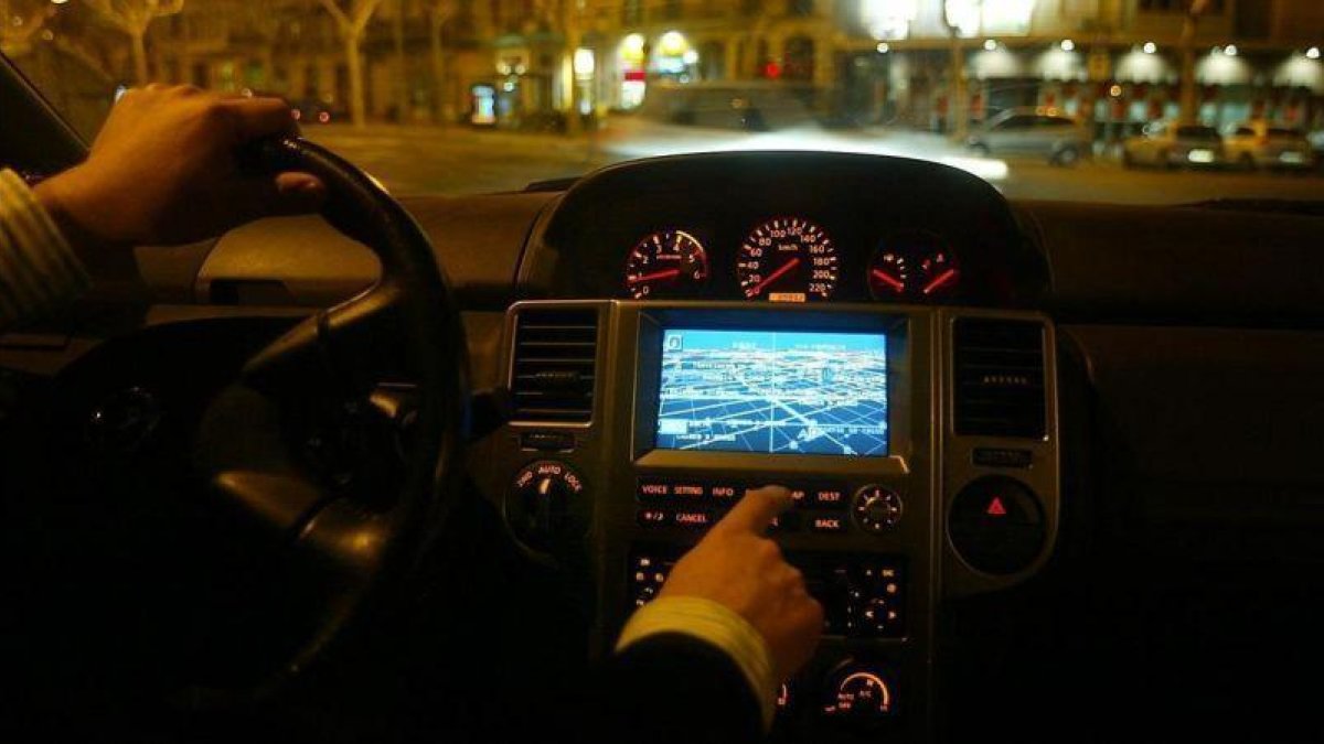 Un conductor manipula el GPS integrado en su vehículo.-JULIO CARBÓ