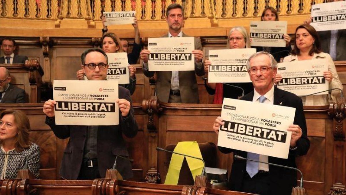 Los concejales del PDECat en Barcelona muestran carteles pidiendo la libertad de los encarcelados. Con un lazo amarillo, el lugar que ocupaba el exedil y exconseller Joaquim Forn.-FERRAN NADEU