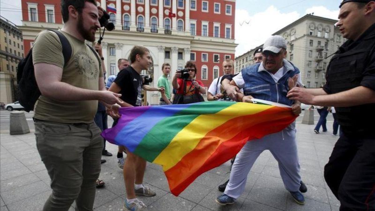 Manifestantes homófobos tratan de romper una bandera gay de un grupo de homosexuales en Moscú-MAXIM ZMEYEV (REUTERS)