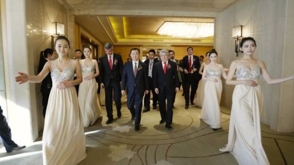 Wang, Cerezo y Gil llegan a la ceremonia de la firma rodeados de elegantes azafatas.-Foto: JASON LEE / REUTERS