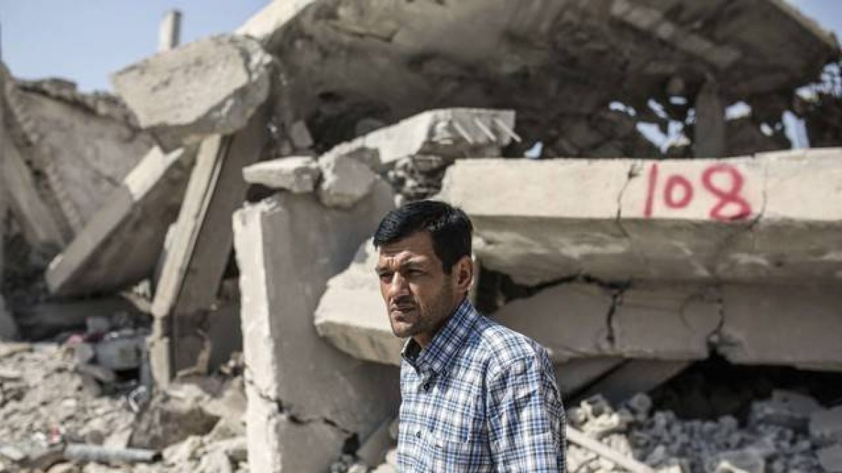 Abdullah Kurdi, el padre de Aylan Kurdi, ante las casas derruidas de sus vecinos, en Kobani.-YASIN AKGUL / AFP