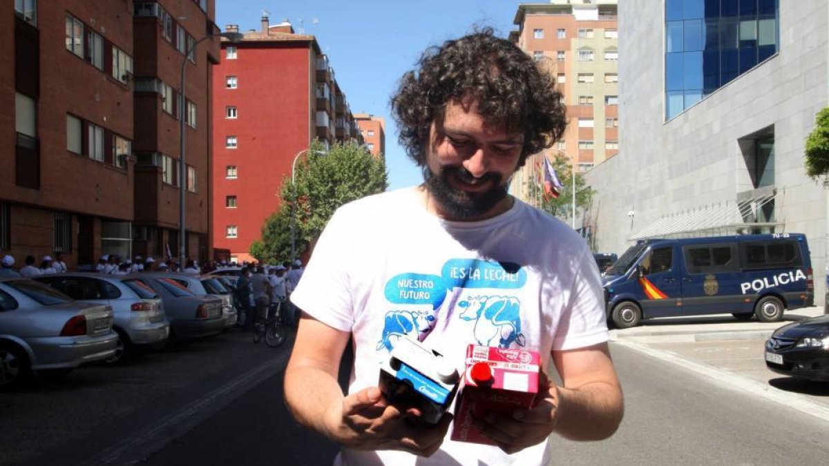 El portavoz del Grupo Mixto y procurador de IU en las Cortes de Castilla y León, José Sarrión, sostiene dos tetrabricks de leche de origen español, repartidas por la 'Marcha blanca' durante la concentración frente a la Conserjería-Ical