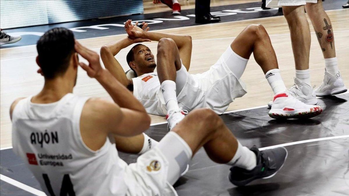 Los jugadores del Madrid, abatidos en el suelo tras la derrota.-EFE