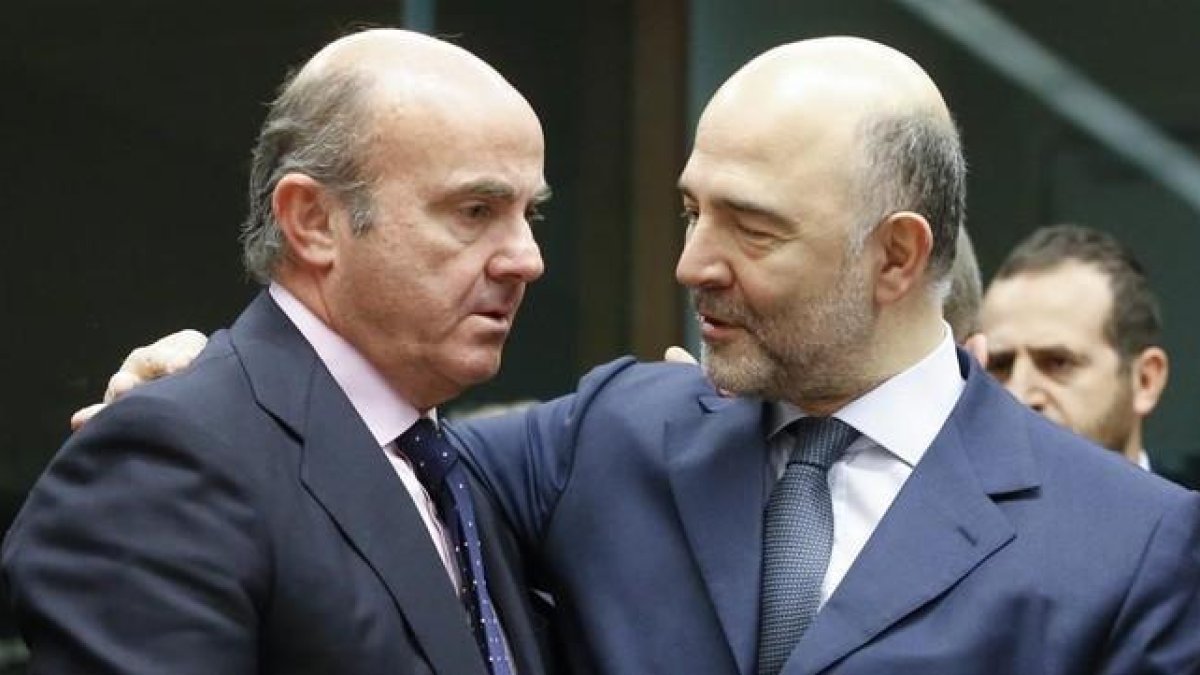 El ministro Luis de Guindos conversa con el comisario de Asuntos Economicos, Pierre Moscovici, en Bruselas el 14 de enero.-OLIVIER HOSLET