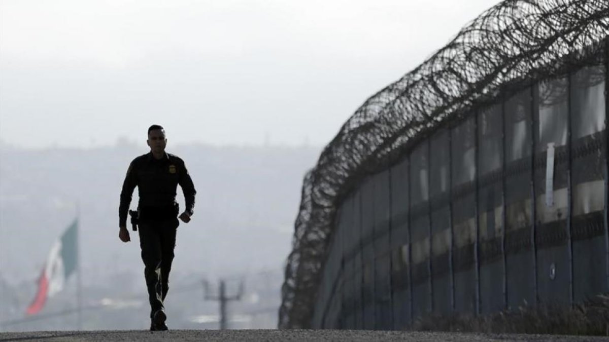 Un agente patrulla la valla que separa México y San Diego.-AP / GREGORY BULL