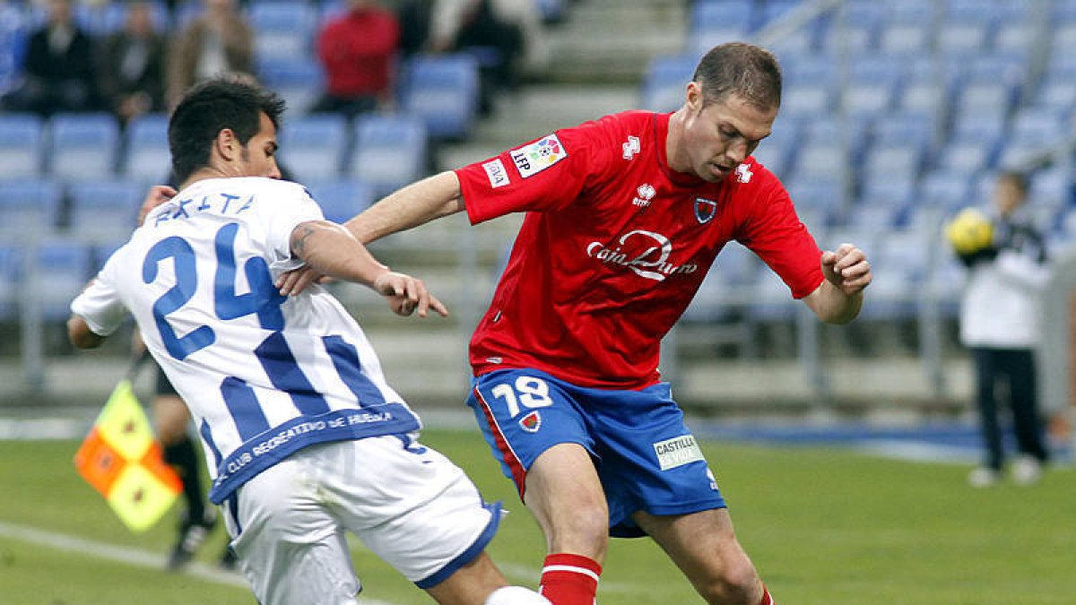 Nano trata de proteger un balón ante un jugador del Recre. / ÁREA 11-