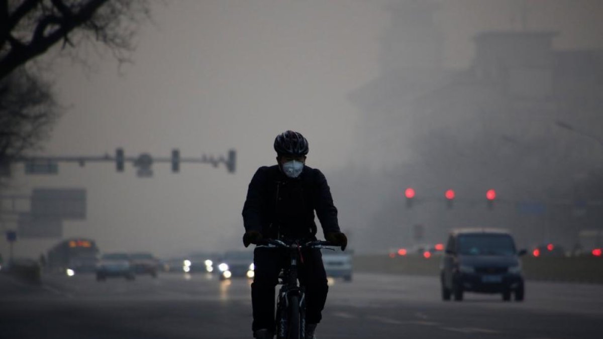 Un ciclista circula por Pekín en un día de alta contaminación.-REUTERS