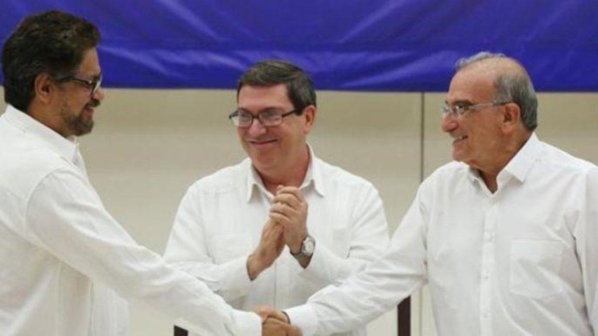 A la izquierda, el líder del equipo negociador de las FARC, Iván Márquez, se da la mano en La Habana con el representante gubernamental, Humberto de la Calle.-ALEXANDRE MENEGHINI / REUTERS