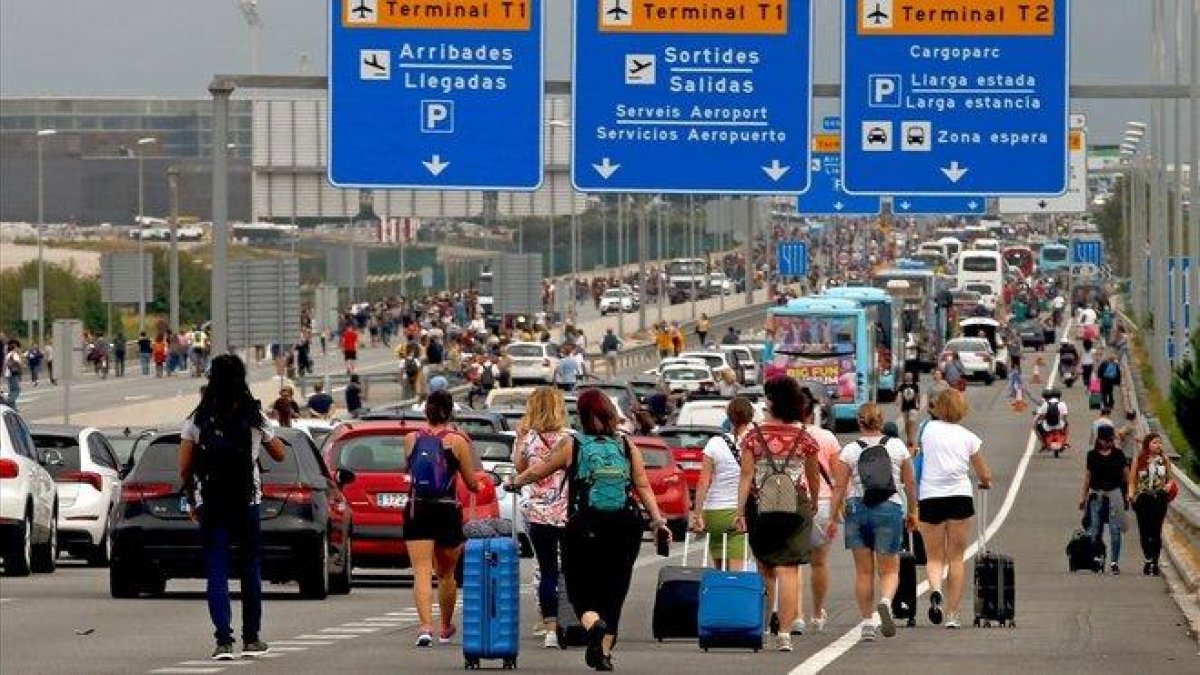 Varios viajeros cerca del Aeropuerto del Prat, afectados por las protestas convocadas por Tsunami Democratic tras la sentencia del juicio del ’procés’.-EFE (TONI ALBIR)