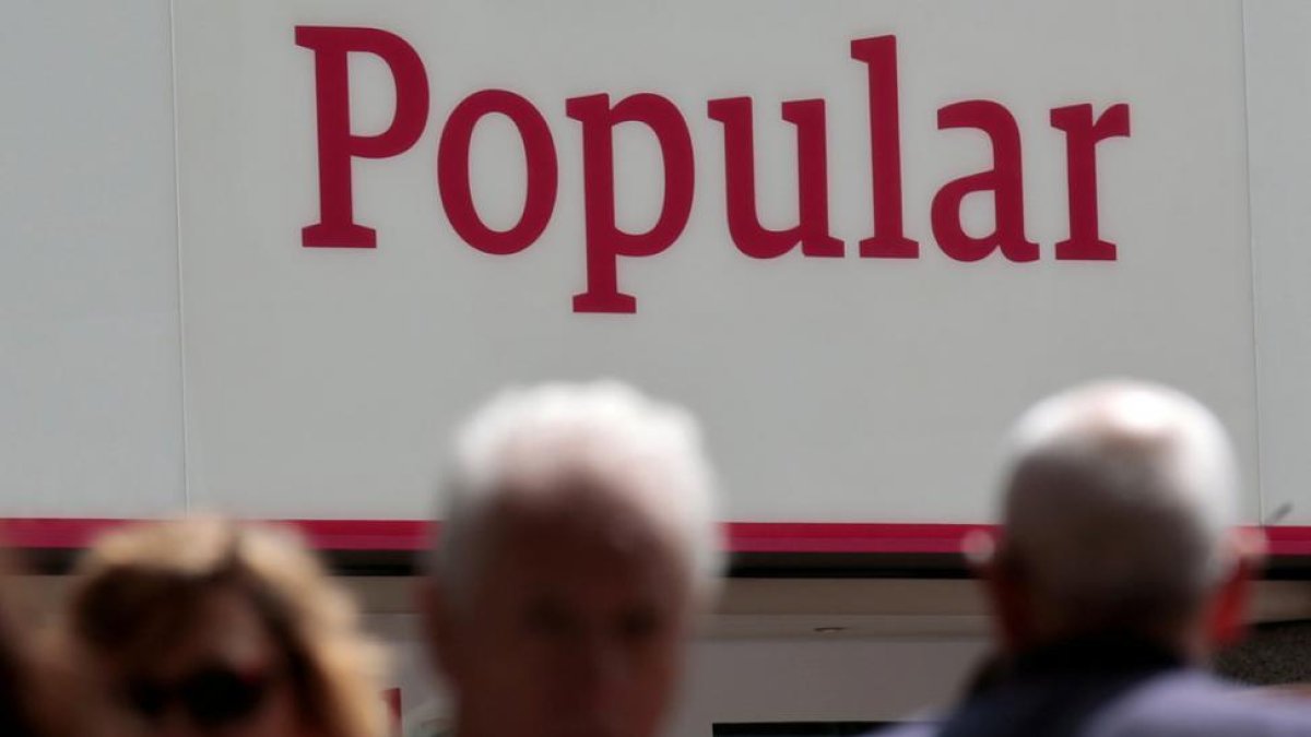 Personas pasando por delante de unas oficinas del Banco Popular.-Andrea Comas / REUTERS