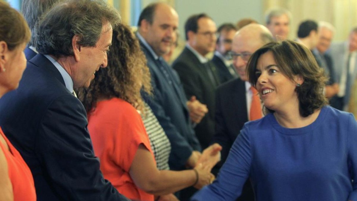 El consejero de Presidencia, José Antonio de Santiago Juárez, se saluda con la vicepresidenta del Gobierno, ayer al inicio de la conferencia.-ICAL