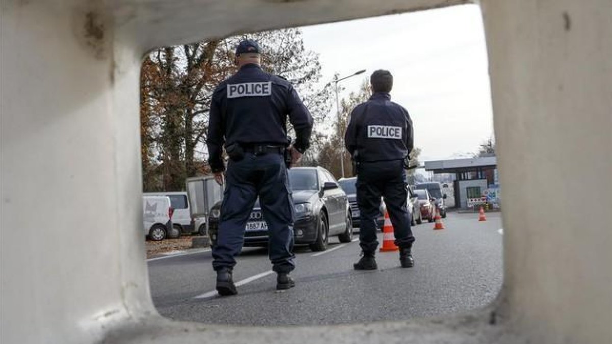 La policía de fronteras francesa controla los coches en el paso fronterizo entre Francia y Suiza en Meyrin, cerca de Ginebra.-