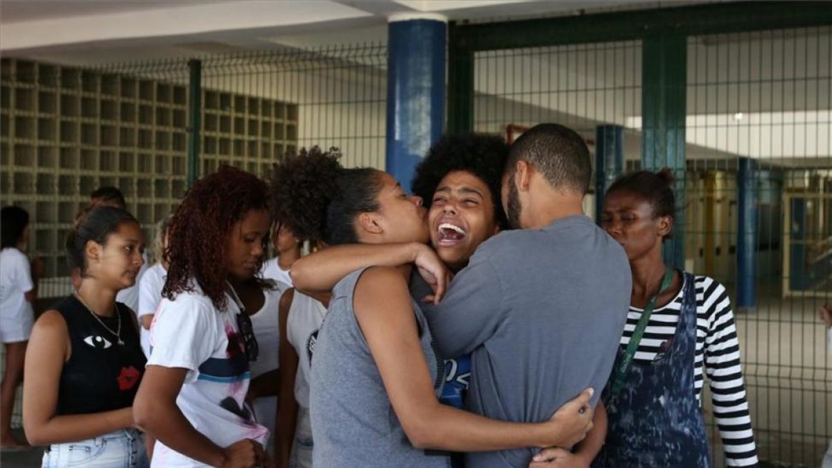 Bianca Alves (centro) es consolada tras conocer la muerte de su hermana, de 13 años, en Río de Janeiro, Brasil.-MARCELO SAYAO
