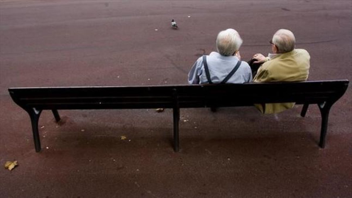 Dos jubilados sentados en un parque.-JULIO CARBÓ