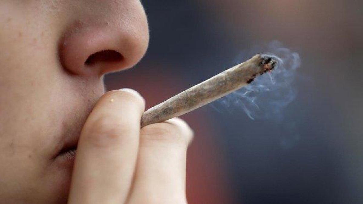 Un joven se fuma un porro durante una concentración a favor de la legalización de la marihuana.-AFP / THOMAS SAMSON