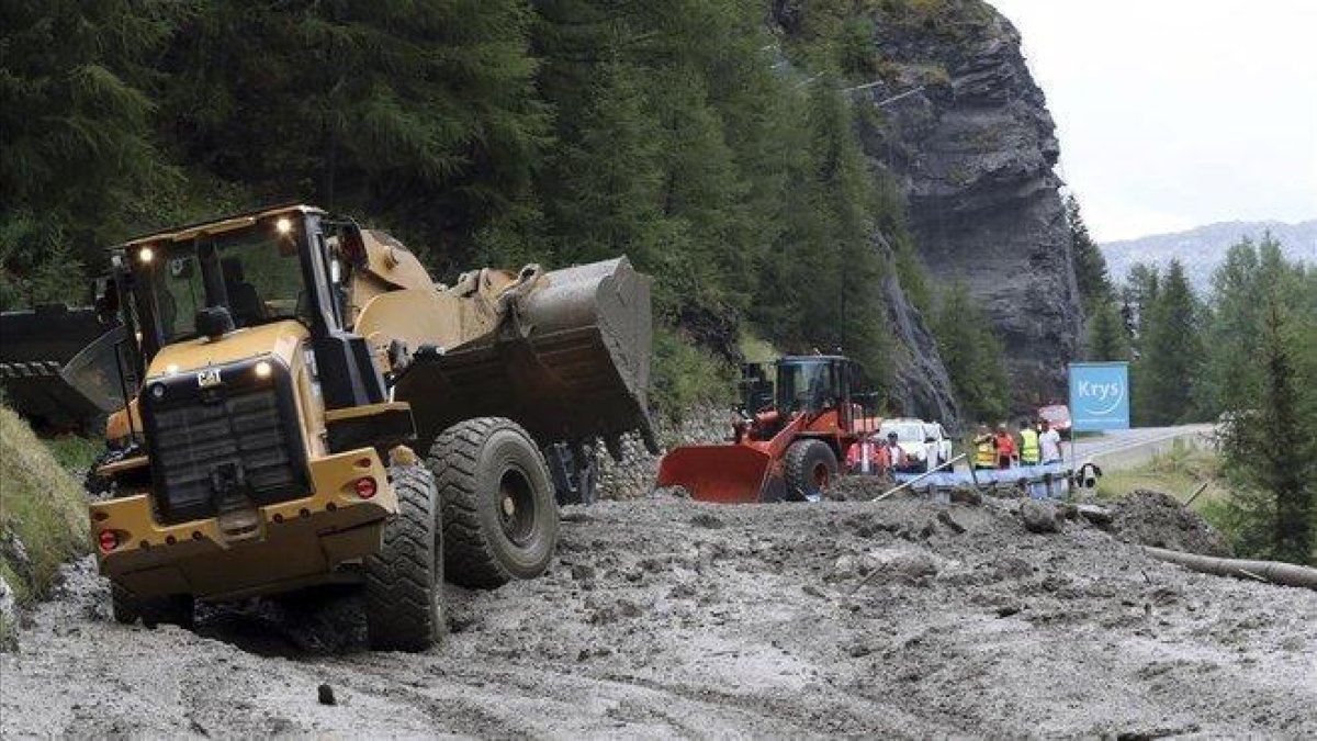 Excavadoras tratan de limpiar la carretera para el paso del Tour de Francia.-AP / THIBAULT CAMUS