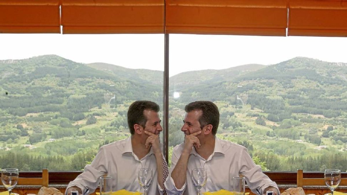 Luis Tudanca bromea con su reflejo en la mesa de un restaurante con Los Ancares al fondo en una comida con militantes en El Espino.-Ical