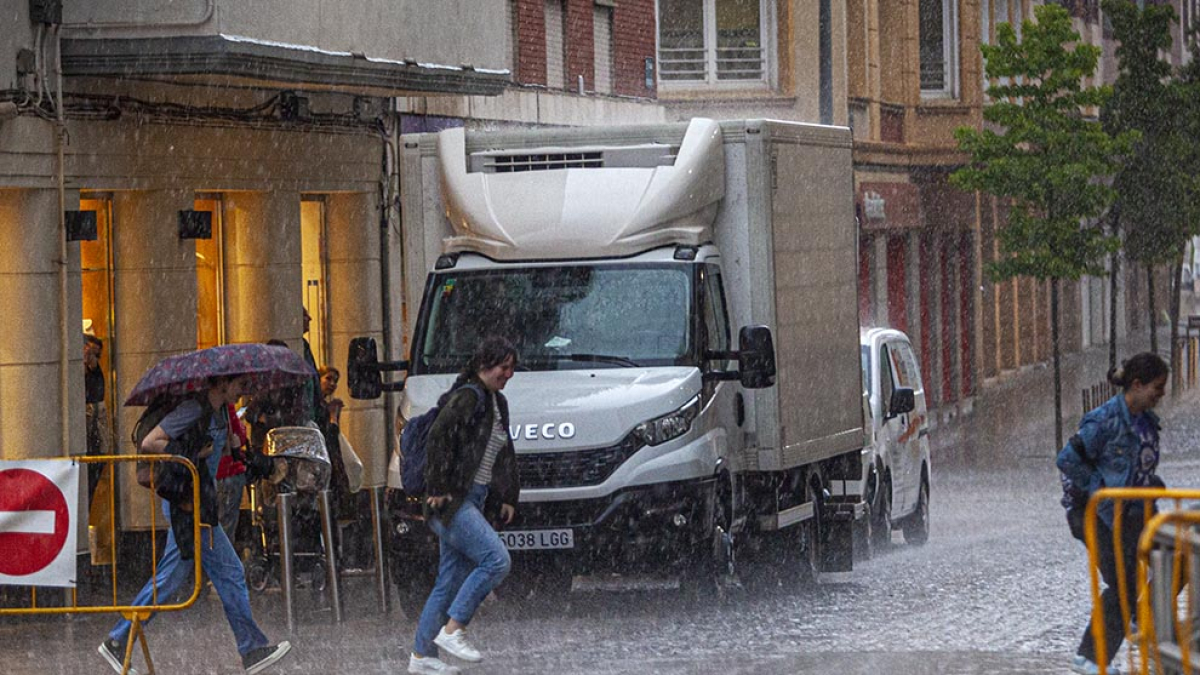 Gente corre para refugiarse de la tormenta de agua y granizo en Soria en una imagen de archivo. MARIO TEJEDOR