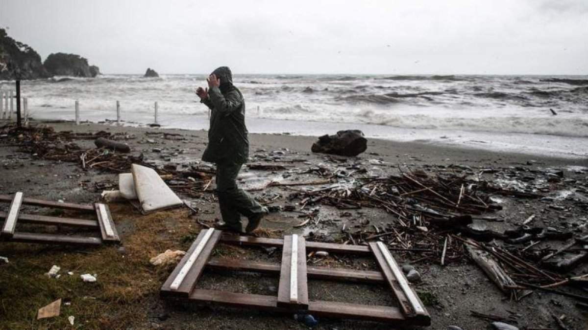 Un hombre camina entre los restos dejados por el temporal en Monterosso al Mare, en Liguria.-AFP / MARCO BERTORELLO