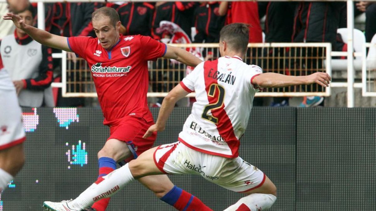 Ripa intenta llevarse un balón ante Galán en Vallecas.-ÁREA 11