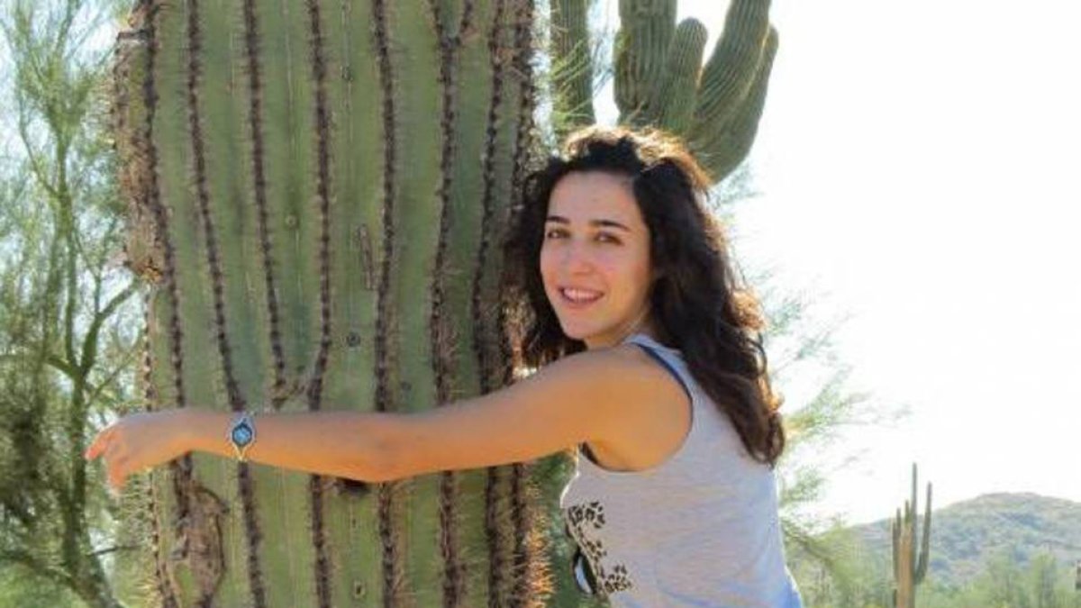 Casandra González Rodríguez posa abrazada a un cactus.-