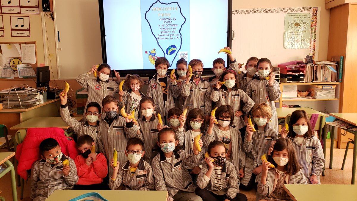 Jóvenes alumnos de Escolapios simbolizan las videollamadas a la Palma con sus plátanos para animar a sus compañeros palmeros. HDS