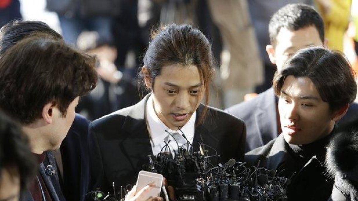 El cantante Jung Joon-young, en el centro, al llegar a la comisaría central de Seúl, el pasado marzo.-AP / AHN YOUNG-JOON