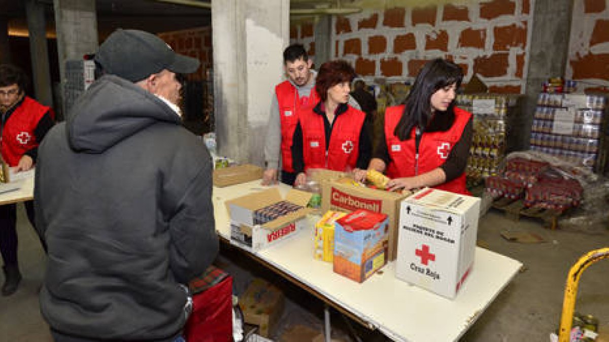 Reparto de comida a personas necesitadas por voluntarios de Cruz Roja. / ÁLVARO MARTÍNEZ-