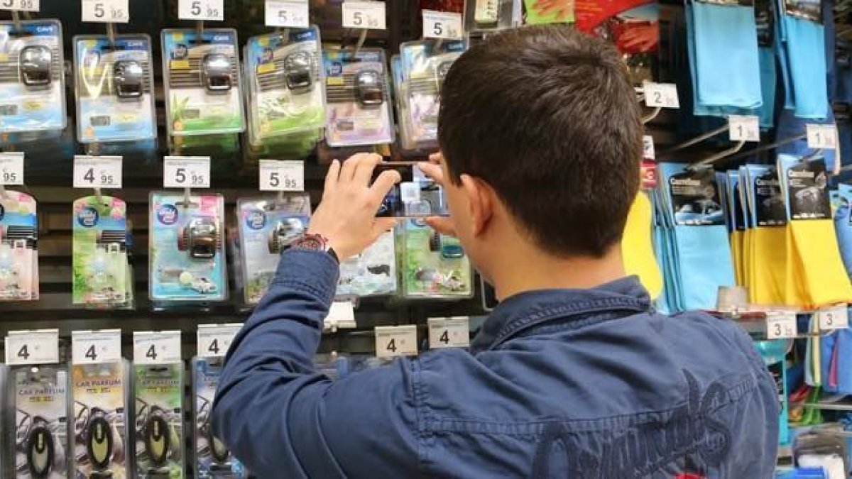 Un usuario escanea precios en una tienda.-