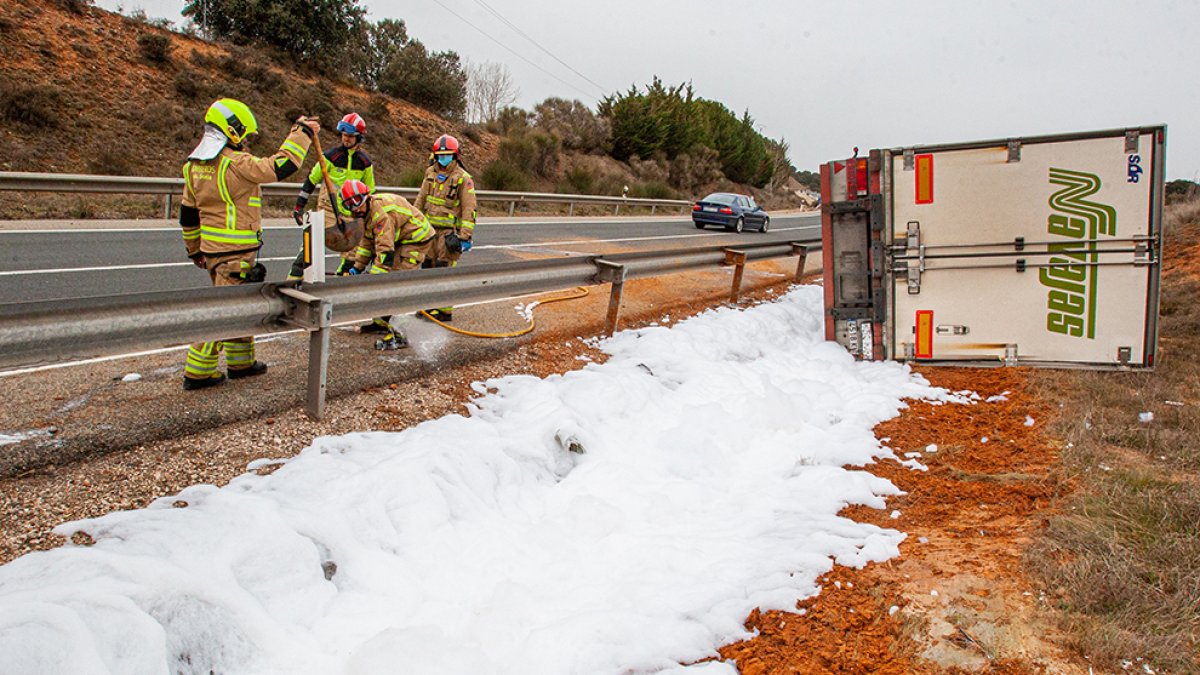 Los bomberos atienden la fuga de gasóleo en el camión siniestrado - MARIO TEJEDOR