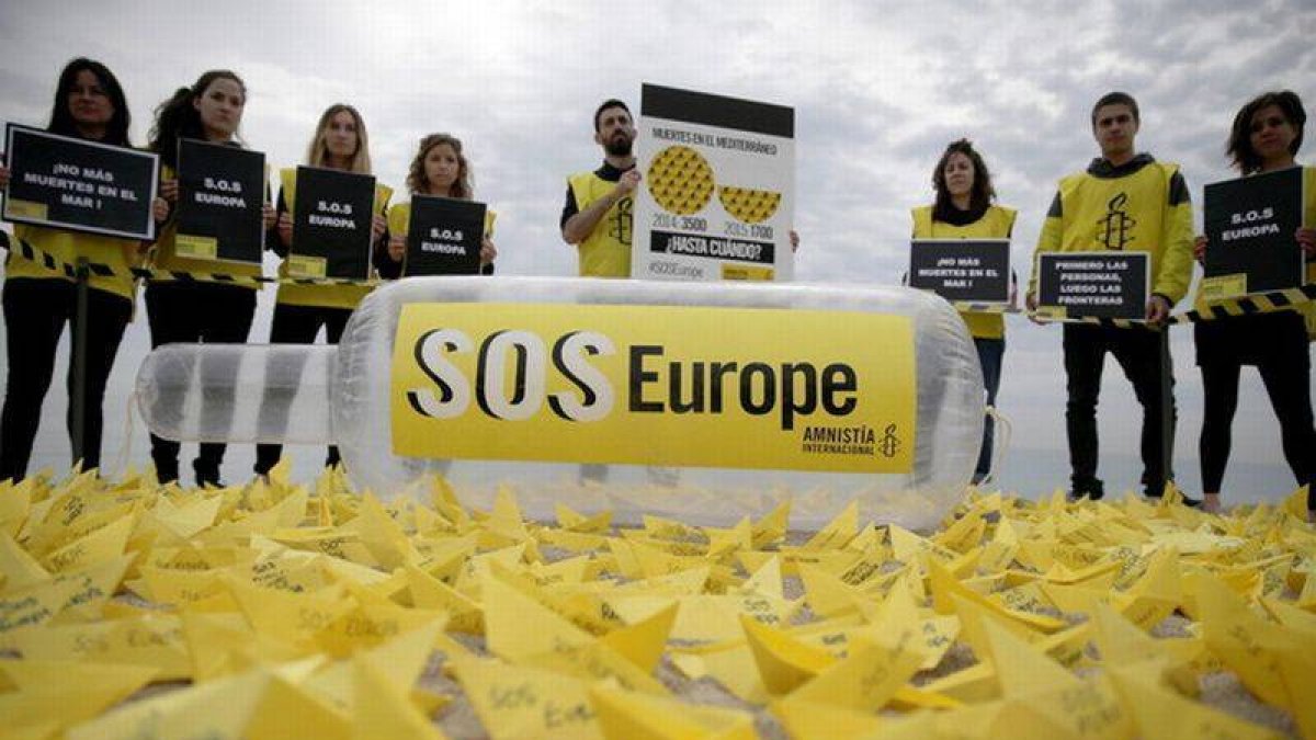 Activistas de Amnistía Internacional denuncian en la playa de Sant Sebastià de Barcelona las muertes de migrantes en el Mediterráneo.-Foto: EFE