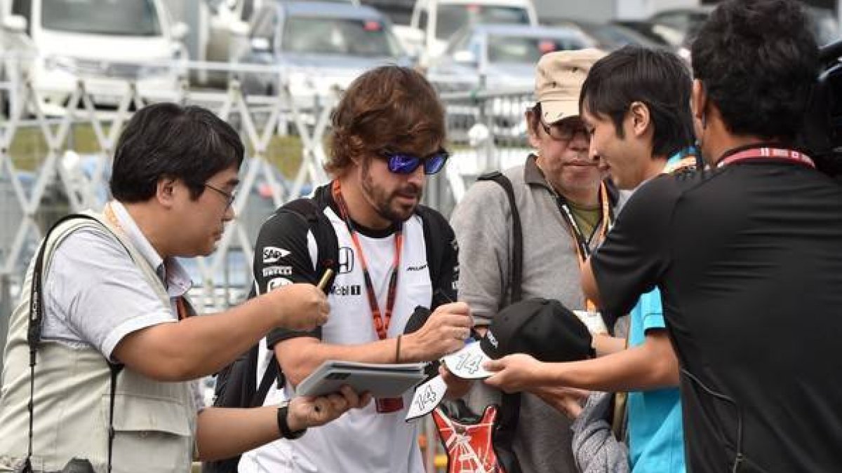 Fernando Alonso firma autógrafos en el circuito de Suzuka, este sábado.-AFP / KAZUHIRO NOGI