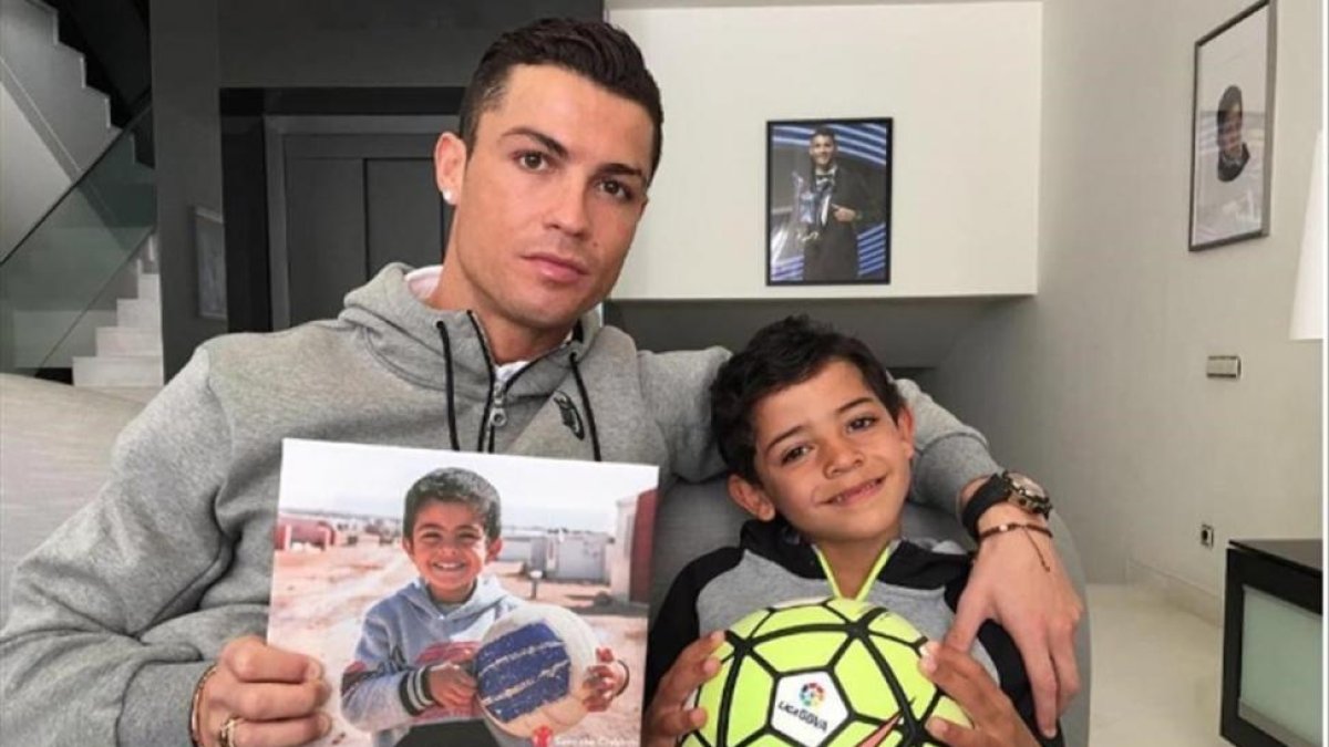 Cristiano Ronaldo ha subido en sus cuentas de Facebook e Instagram una imagen junto a su hijo en la que sostiene una foto de un pequeño sirio.-