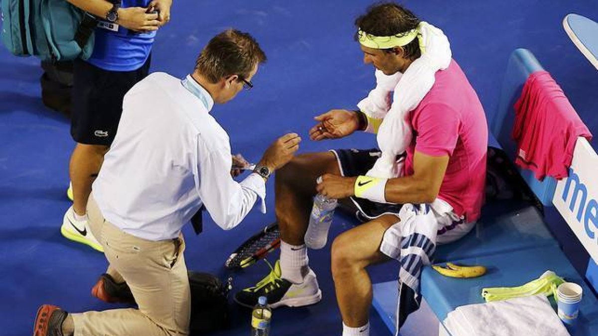 Rafael Nadal es atendido por un médico durante el partido contra Tim Smyczek, durante la segunda ronda del Abierto de Australia.-Foto: REUTERS / CARLOS BARRIA