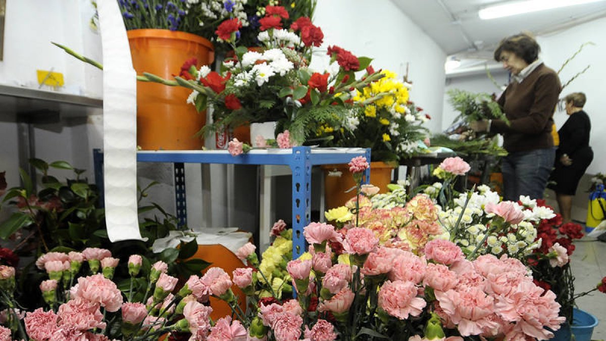 Una mujer prepara centros de flores en un establecimiento de Soria, ayer. / ÚRSULA SIERRA-