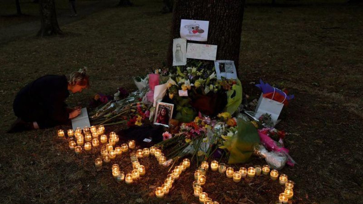 Una muchacha escribe un mensaje de condolencias en el altar montado a las puertas de la mezquita Al Noor, en Christchurch.-EFE