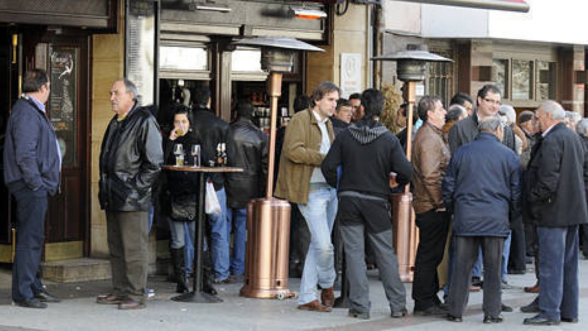 Un grupo de personas toma algo bajo las setas calefactoras y junto a las mesas exteriores de un céntrico bar de la capital soriana. / VALENTÍN GUISANDE-