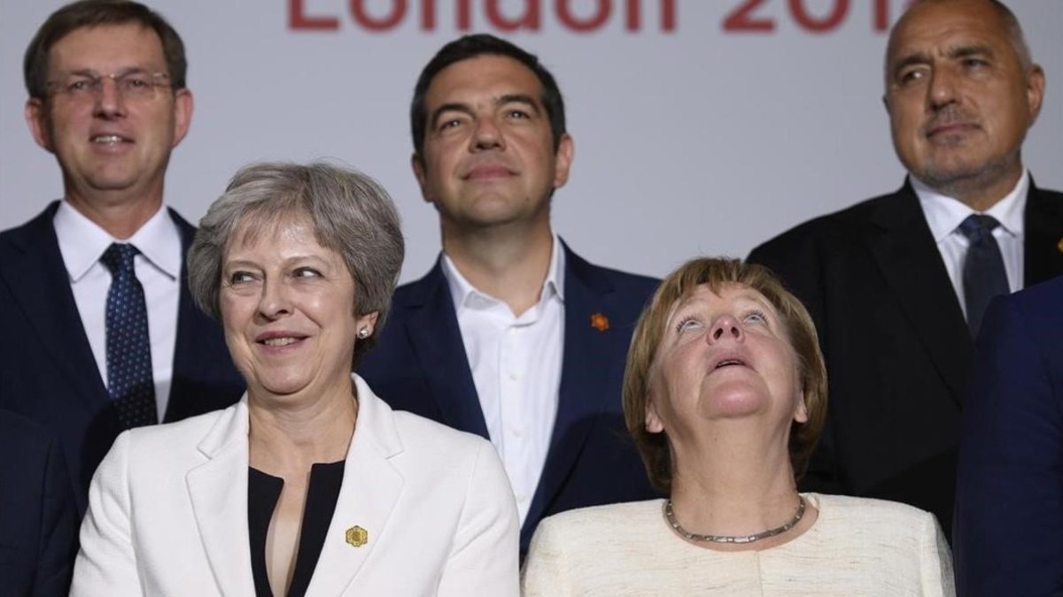 Theresa May y Angela Merkel con otros dirigentes durante la cumbre de los Balcanes occidentales. /-AP / LEON NEAL