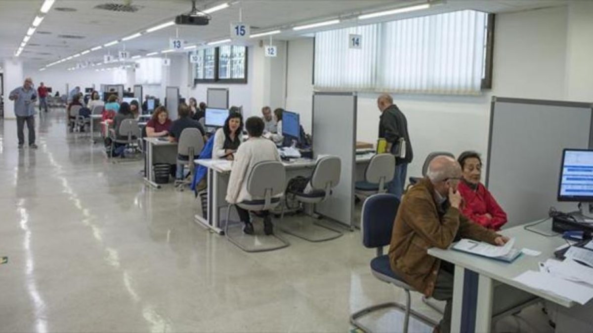Unos ciudadanos hacen la declaración de la renta en una oficina de Barcelona de la Agencia Tributaria, el 2017.-/ FERRAN SENDRA