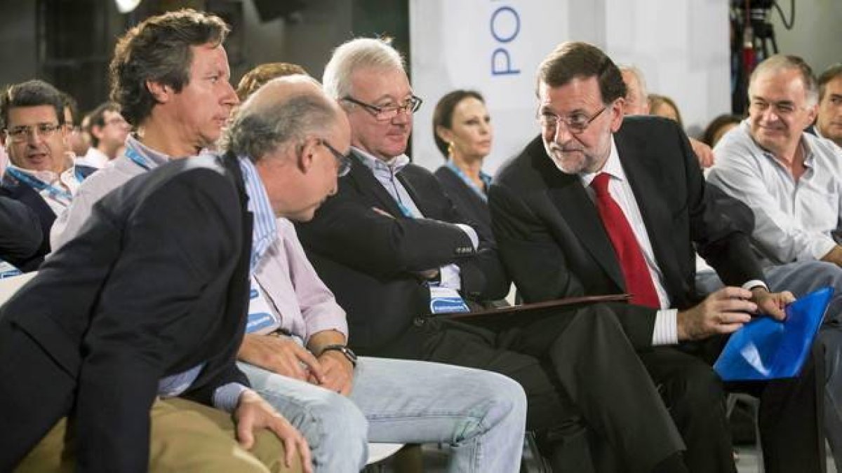Rajoy habla con Cristóbal Montoro ante el presidente del PP de Murcia, Ramón Luis Valcárcel, y Carlos Floriano, durante la Intermunicipal del PP, este domingo en Murcia-Foto: EFE/ MARCIAL GUILLÉN