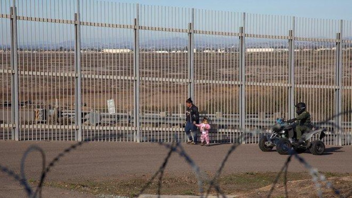 Una mujer migrante es detenida por la policia estadounidense.-EFE