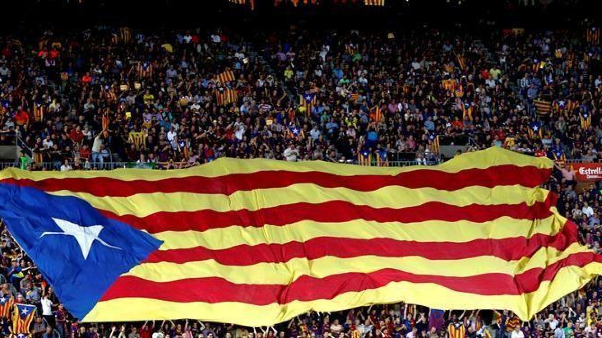 Aficionados del Barcelona despliegan una bandera 
