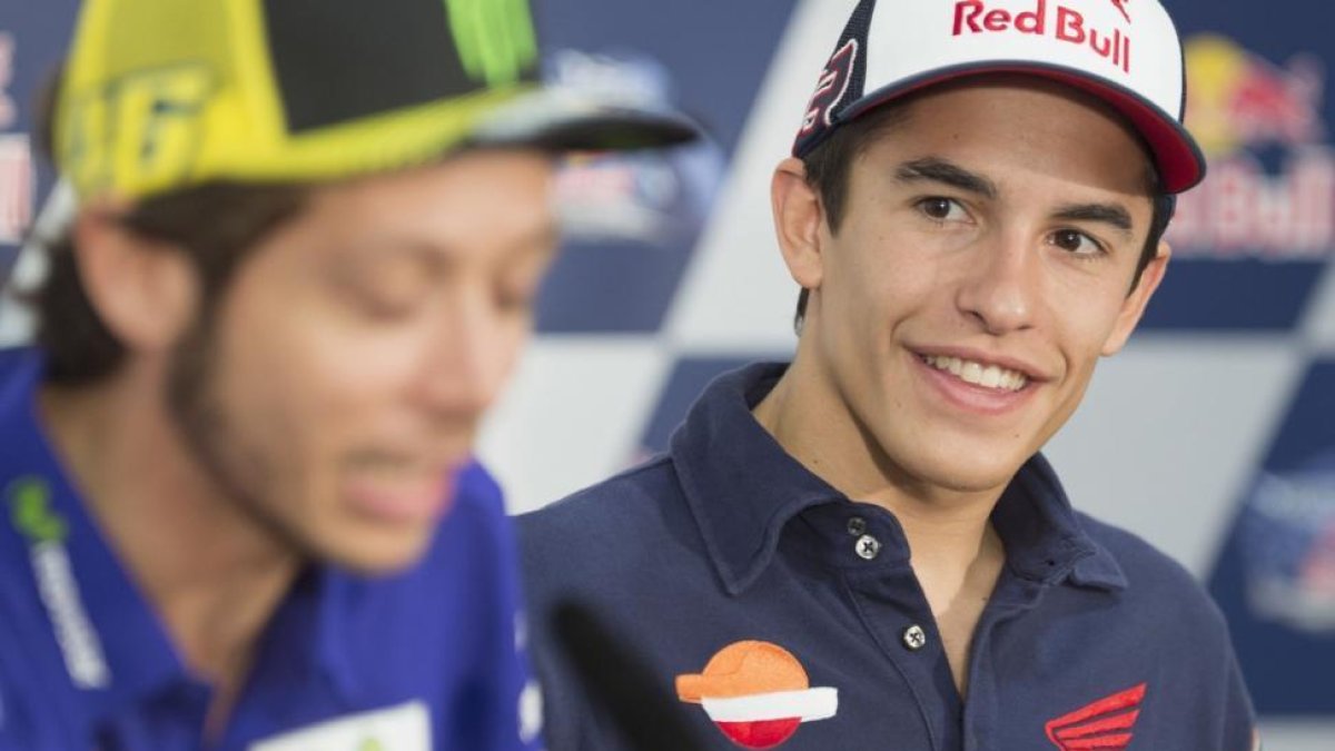 Marc Márquez mira y sonríe ante las palabras de Valentino Rossi.-MIRCO LAZZARI