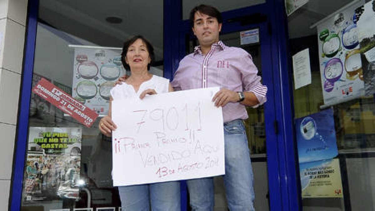 El lotero junto a su madre mostrando el número ganador. / URSULA SIERRA-