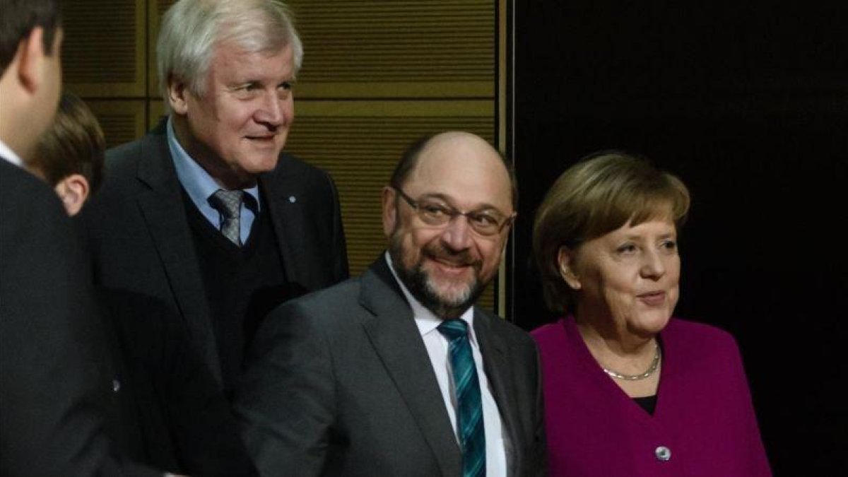 Merkel (derecha), junto a Schulz (centro) y Horst Seehofer, presidente de la CSU, durante la reunión en la sede del Partido Socialdemócrata (SPD) en Berlín, el 2 de febrero.-EFE / CLEMENS BILAN