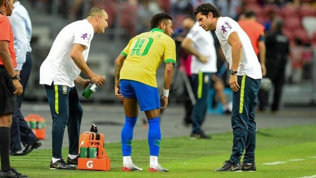 Neymar se queja de la lesión muscular que sufrió en la pierna izquierda en Singapur con Brasil.-AFP / ROSLAN RAHMAN