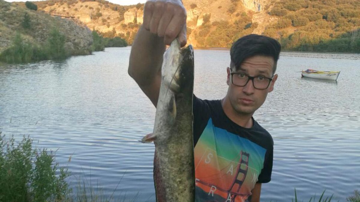 Un aficionados con un siluro capturado en el embalse de Los Rábanos.-CEDIDA