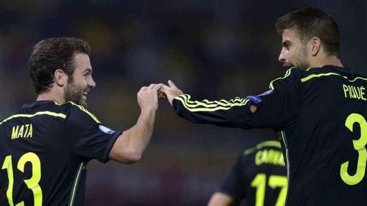 Juan Mata y Gerard Piqué, en el partido Macedonia-España.-AFP / NIKOLAY DOYCHINOV