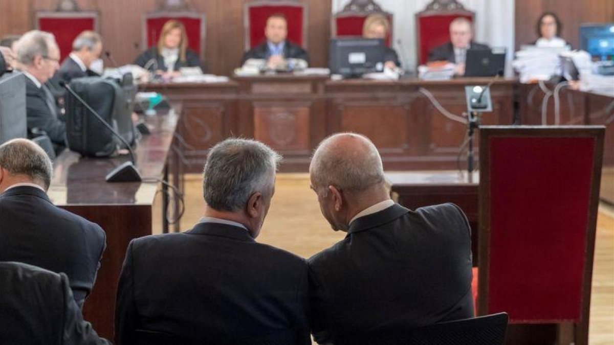 Griñán y Chaves conversan en el banquillo de los acusados, en el inicio del juicio por el caso ERE, en diciembre pasado.-EFE/ JULIO MUÑOZ